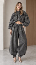 Full front view of model wearing charcoal gray washed denim cropped blouson top and balloon pants set with heels
