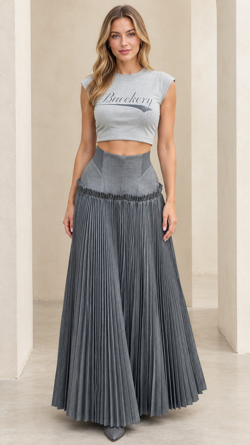 Full front view of model wearing grey cropped tee and grey pleated high-waisted maxi skirt set