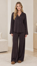 Front full-length view of model wearing dark brown long sleeve button-down pajama set with wide-leg pants