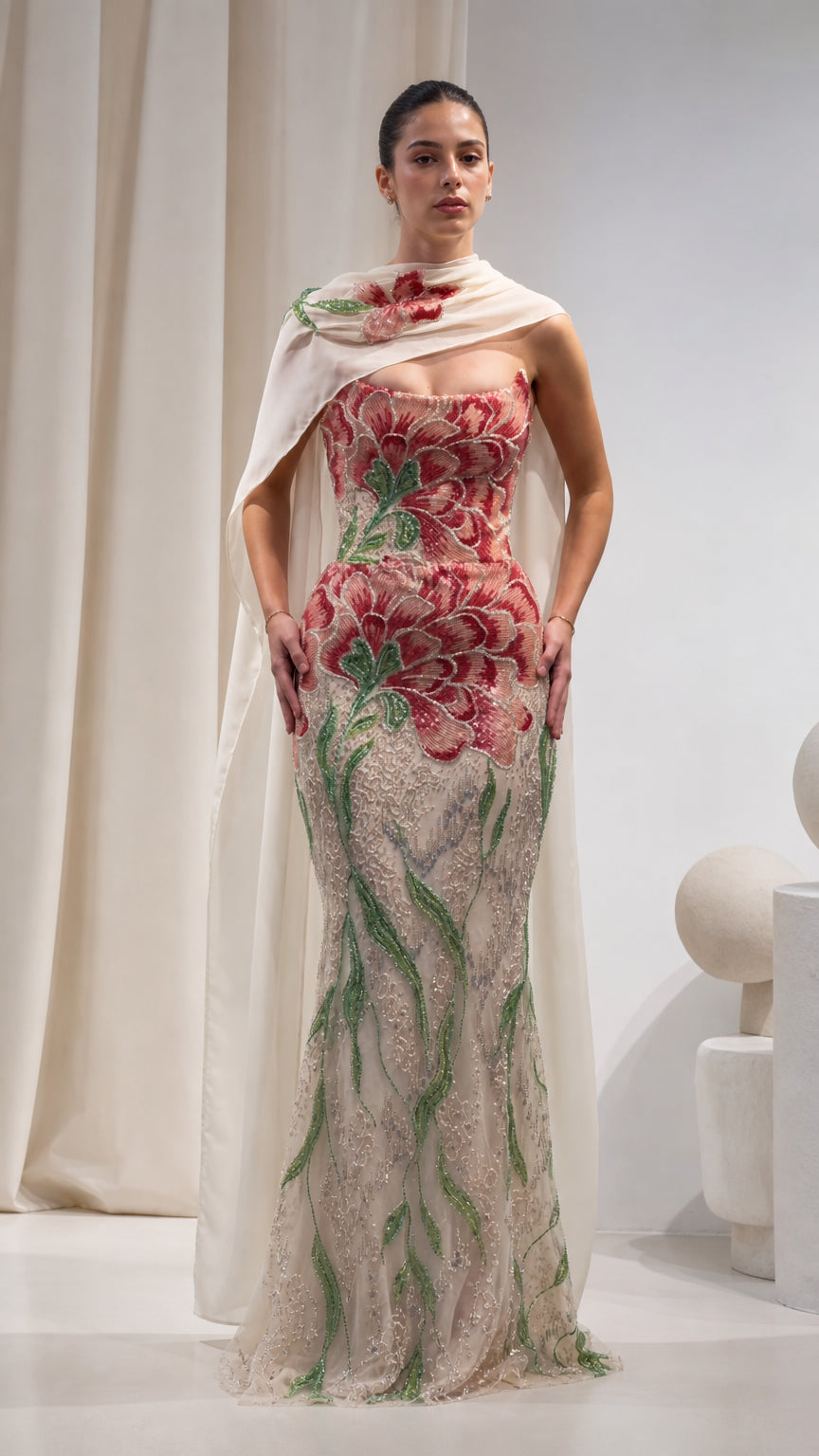 Front view of Champagne floral beaded strapless mermaid gown with draped cape