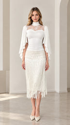 Front view of model wearing white lace yoke capelet top and fringe midi skirt set