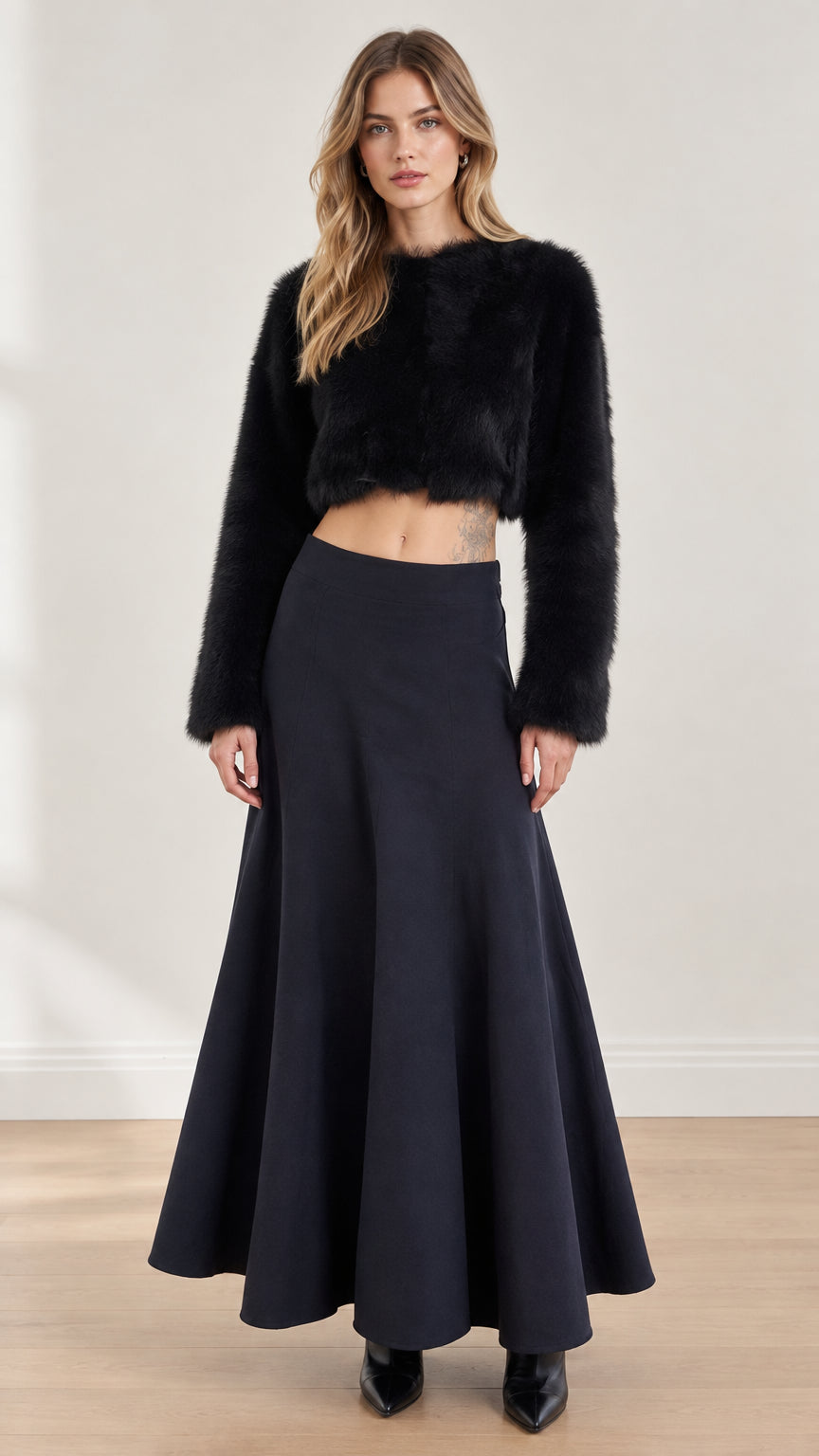Model wearing black fuzzy long sleeve crop top and matching flared maxi skirt front view