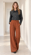 Full front view of model wearing black cropped diamond-quilted jacket and rust wide-leg trousers