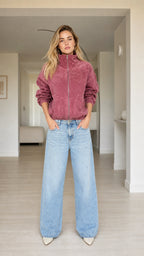 Full front view of model wearing dusty rose plush zip-up bomber jacket with wide-leg jeans