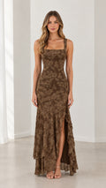 Front view of woman wearing brown square neck floral jacquard maxi dress with ruffle slit