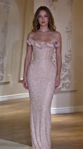 Front view of model wearing a blush pink off-the-shoulder beaded evening gown with rosette neckline