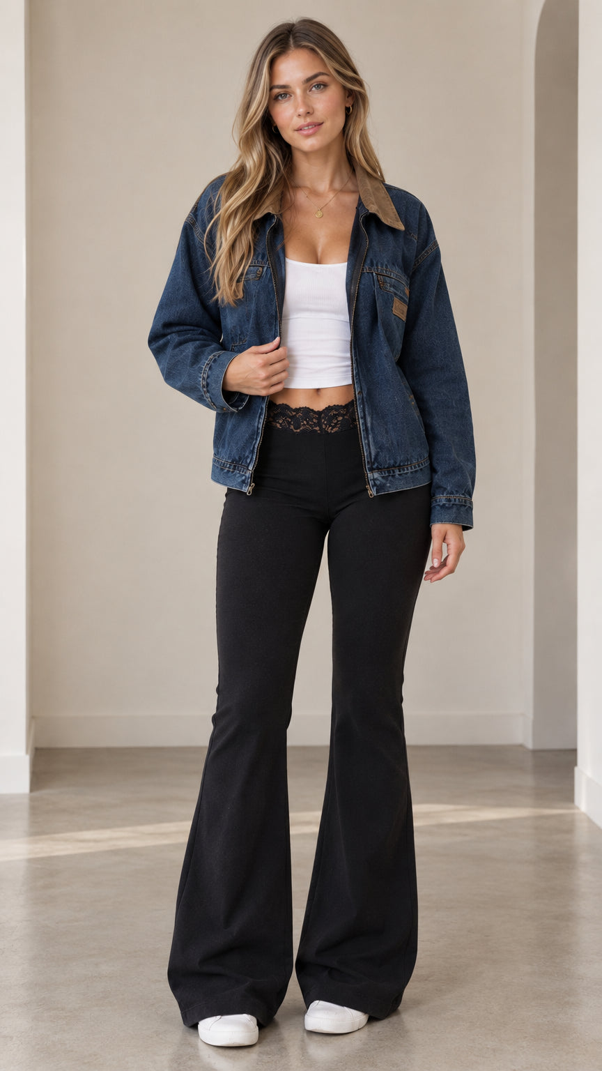 Front view of model wearing a classic blue zip-up denim jacket with brown corduroy collar and black flared pants