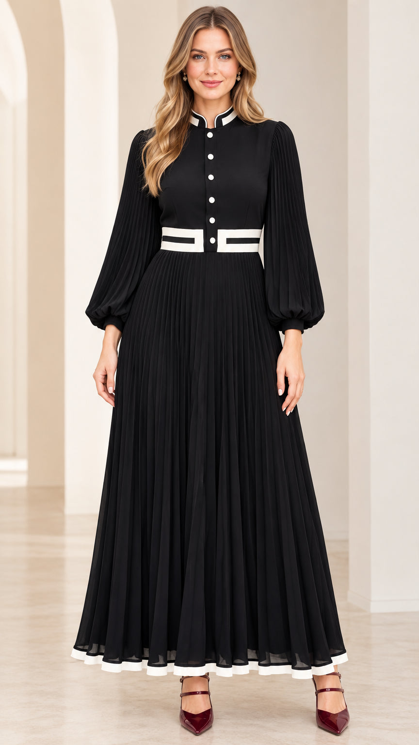 Front view of black long sleeve pleated maxi dress with white contrast trim and stand collar
