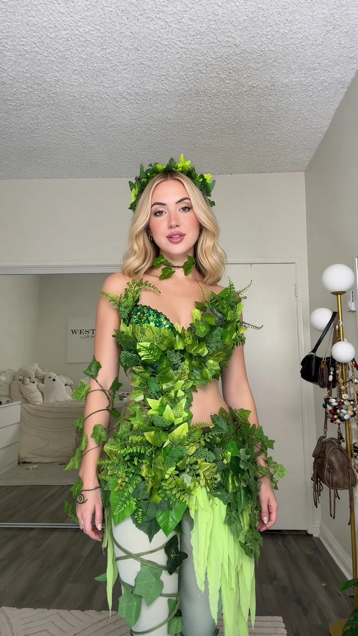 Front view of model wearing green enchanted leaf fairy costume top, tassel skirt, and vine tights