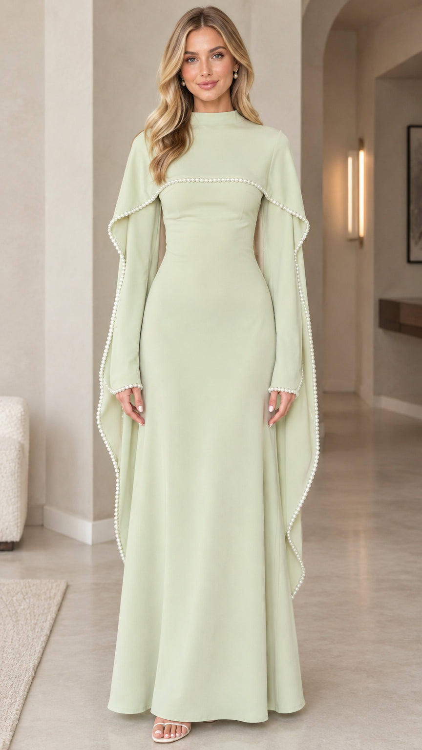 Front view of woman wearing sage green high-neck pearl-trimmed cape sleeve maxi evening dress