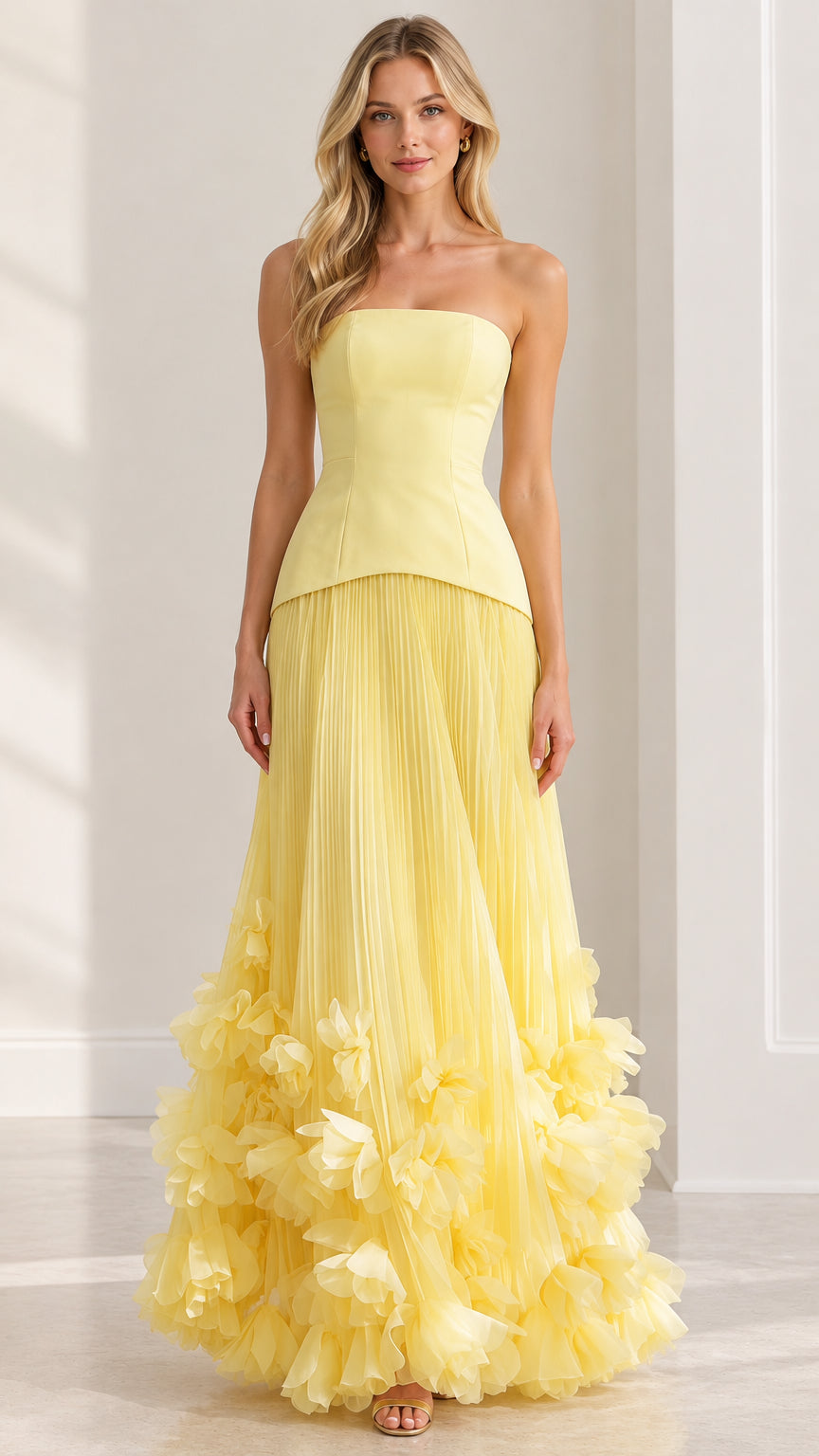 Front full view of strapless pastel yellow pleated gown with 3D floral applique hem