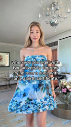 Front view of model wearing a blue floral strapless tiered mini dress with ruffled trim