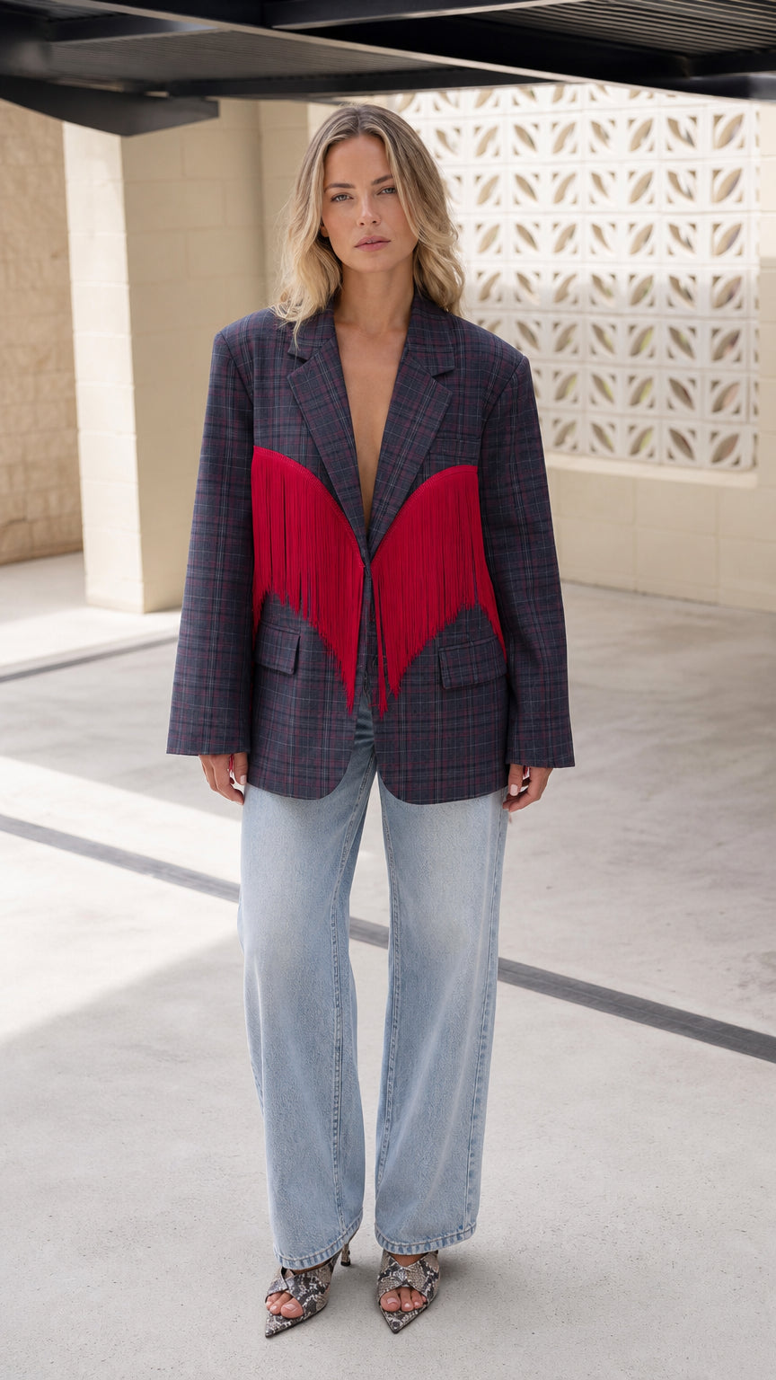 Front view of model wearing Navy Plaid oversized blazer with red wing fringe detail