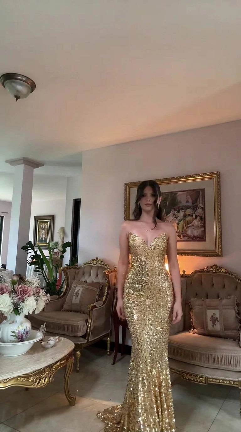 Front view of woman wearing strapless gold sequin mermaid evening gown with sweetheart neckline