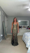 Front view of woman wearing black and gold sequin evening gown with front slit