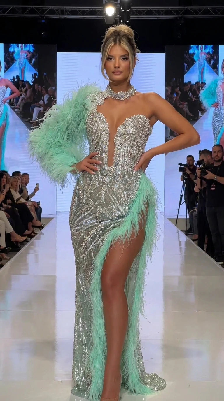 Front runway view of silver sequin evening gown with mint green feather sleeve and slit trim