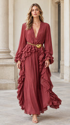 Front full-length view of woman wearing rust red pleated deep V-neck maxi dress with ruffles and waist belt
