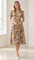 Front full-length view of woman wearing sage green floral wrap midi dress with short sleeves