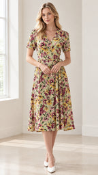 Front full-length view of woman wearing sage green floral wrap midi dress with short sleeves
