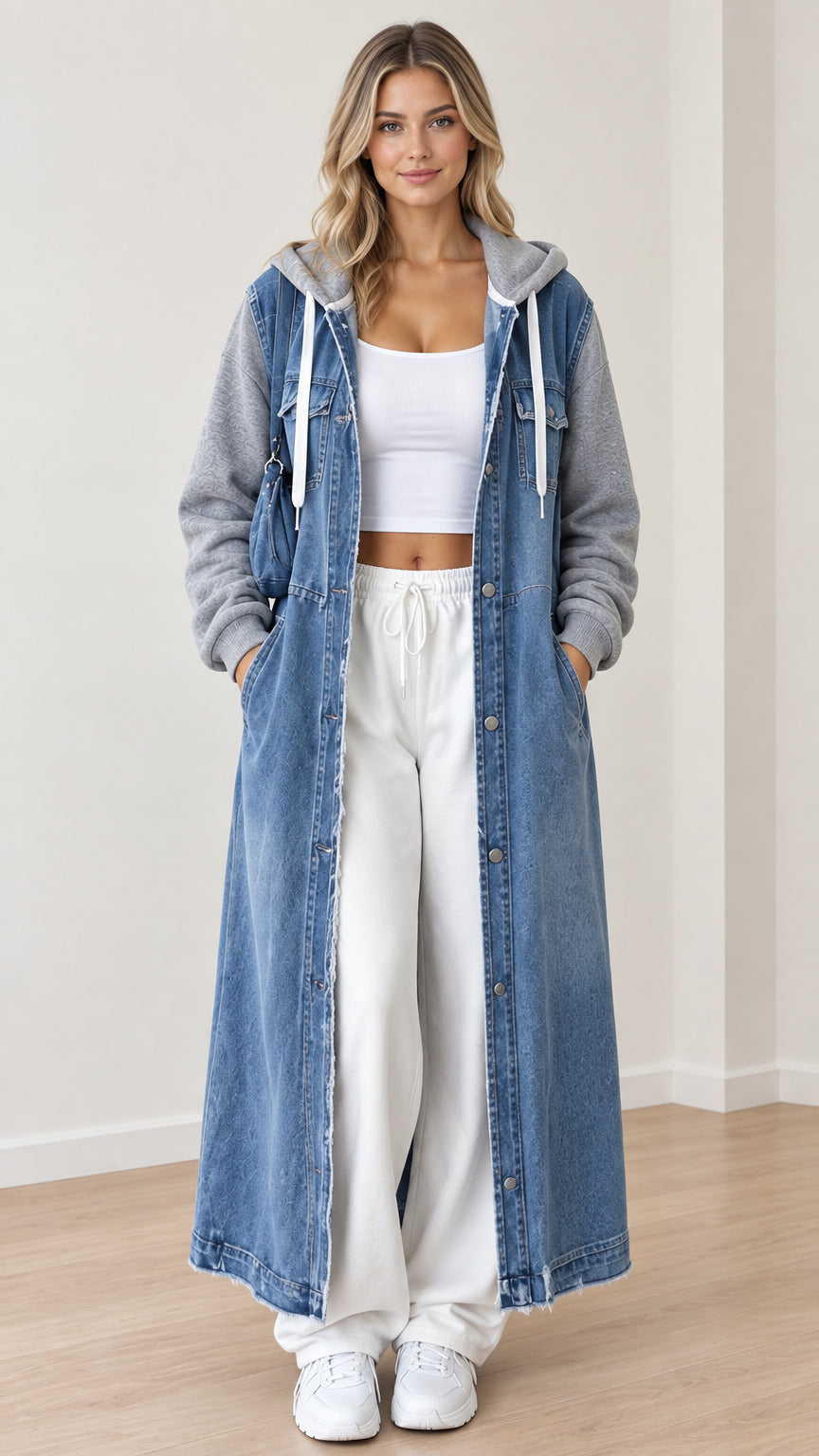 Front view of model wearing blue maxi hooded denim coat with gray sweatshirt sleeves and white trousers