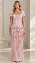 Front full view of woman wearing pink floral appliqué corset maxi gown with fringe sleeves