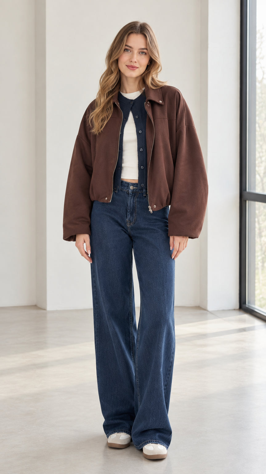 Front full view of woman wearing brown collared zip-up jacket with wide-leg jeans