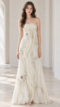 Full front view of ivory strapless evening gown with floral beadwork and drape overlay