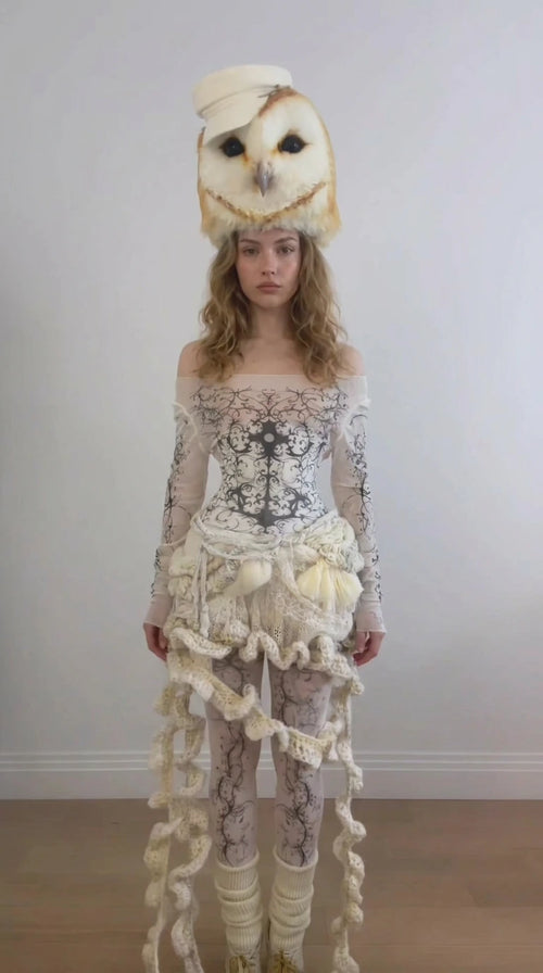 Front full-length view of model wearing the Cream avant-garde baroque print bodysuit ensemble with ruffled waist drape