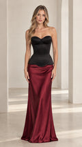 Front view of model wearing black sweetheart corset top with burgundy satin maxi skirt