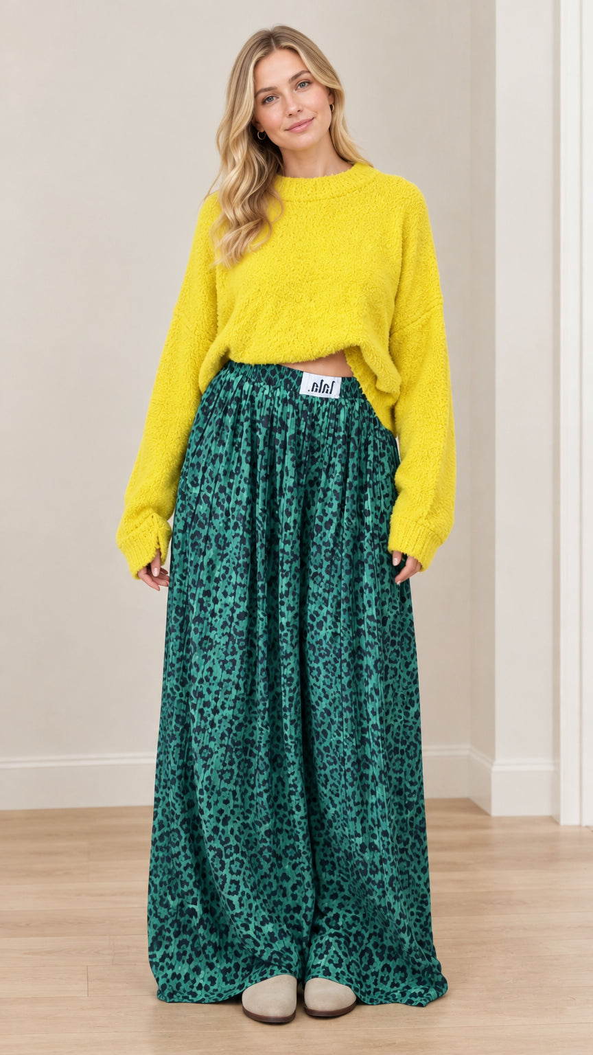 Front view of model wearing bright yellow knit sweater and emerald green leopard print wide-leg pants