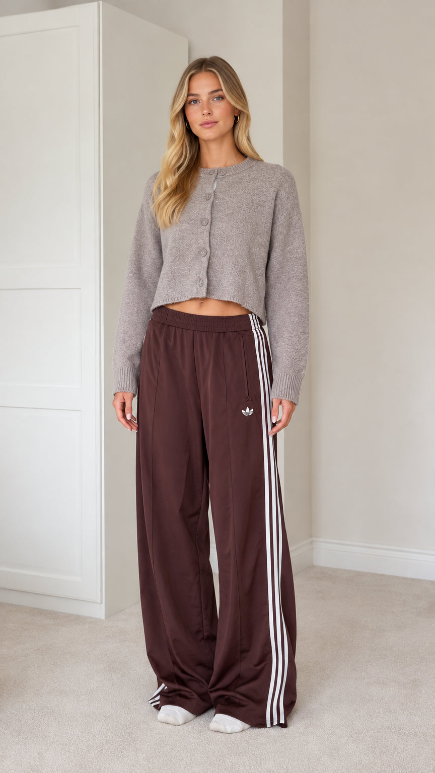 Full front view of model wearing grey cropped knit cardigan and brown wide leg track pants with white stripes