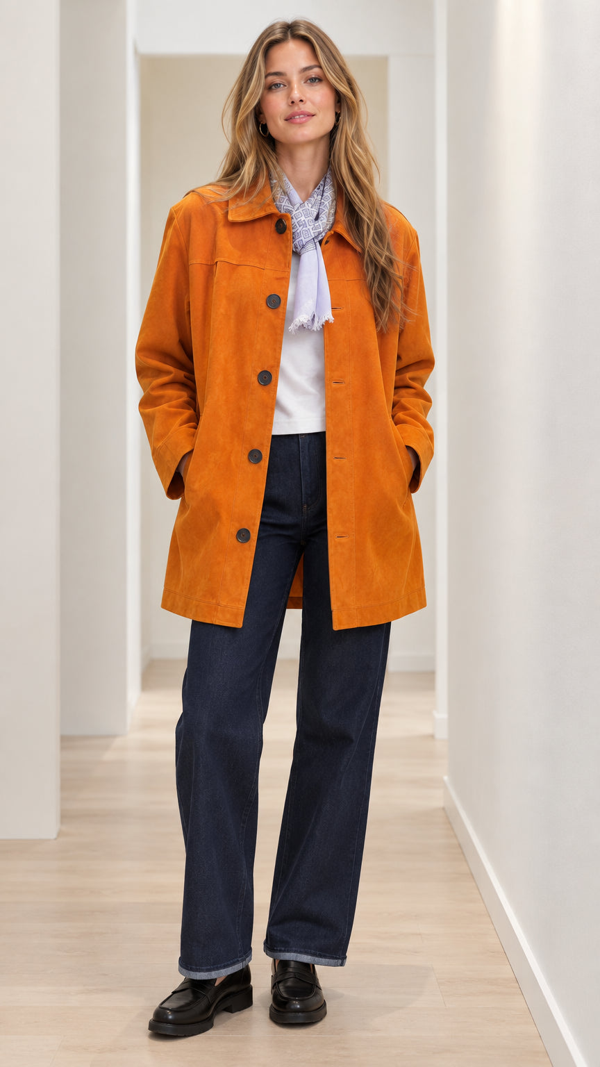 Front view of woman wearing cognac mid-length button-front car coat with jeans