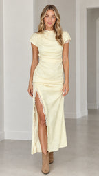 Front full view of woman wearing butter yellow lace-trim ruched maxi dress with side slit