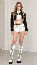 Front view of black cropped military stage jacket with gold chains and white shorts on model