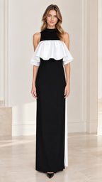 Front view of model wearing black high neck column maxi dress with white contrast ruffle overlay