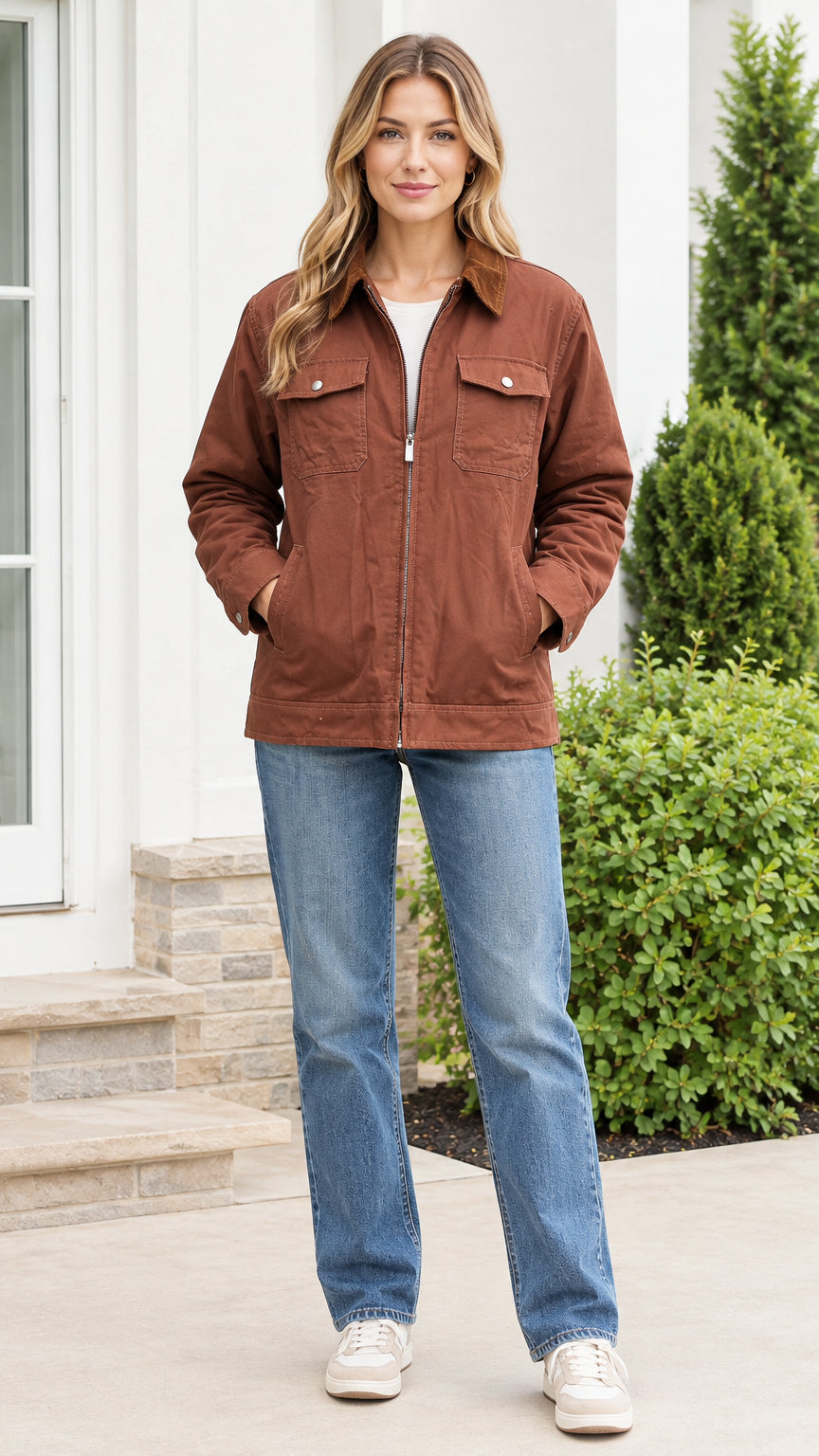 Front view of model wearing a brown canvas utility jacket with corduroy collar and straight leg jeans