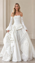 Front view of ivory vintage corset ball gown with lace bell sleeves and draped eyelet skirt