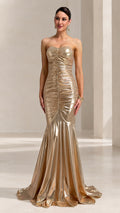 Front full-length view of woman wearing strapless gold metallic ruched mermaid evening gown