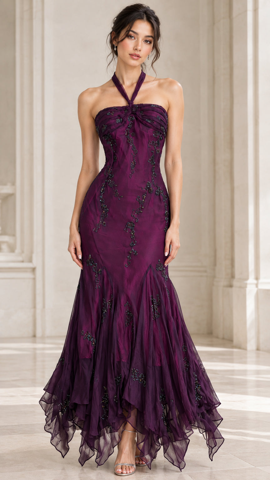 Front view of woman wearing plum purple halter mermaid evening gown with beaded embroidery and tiered hem