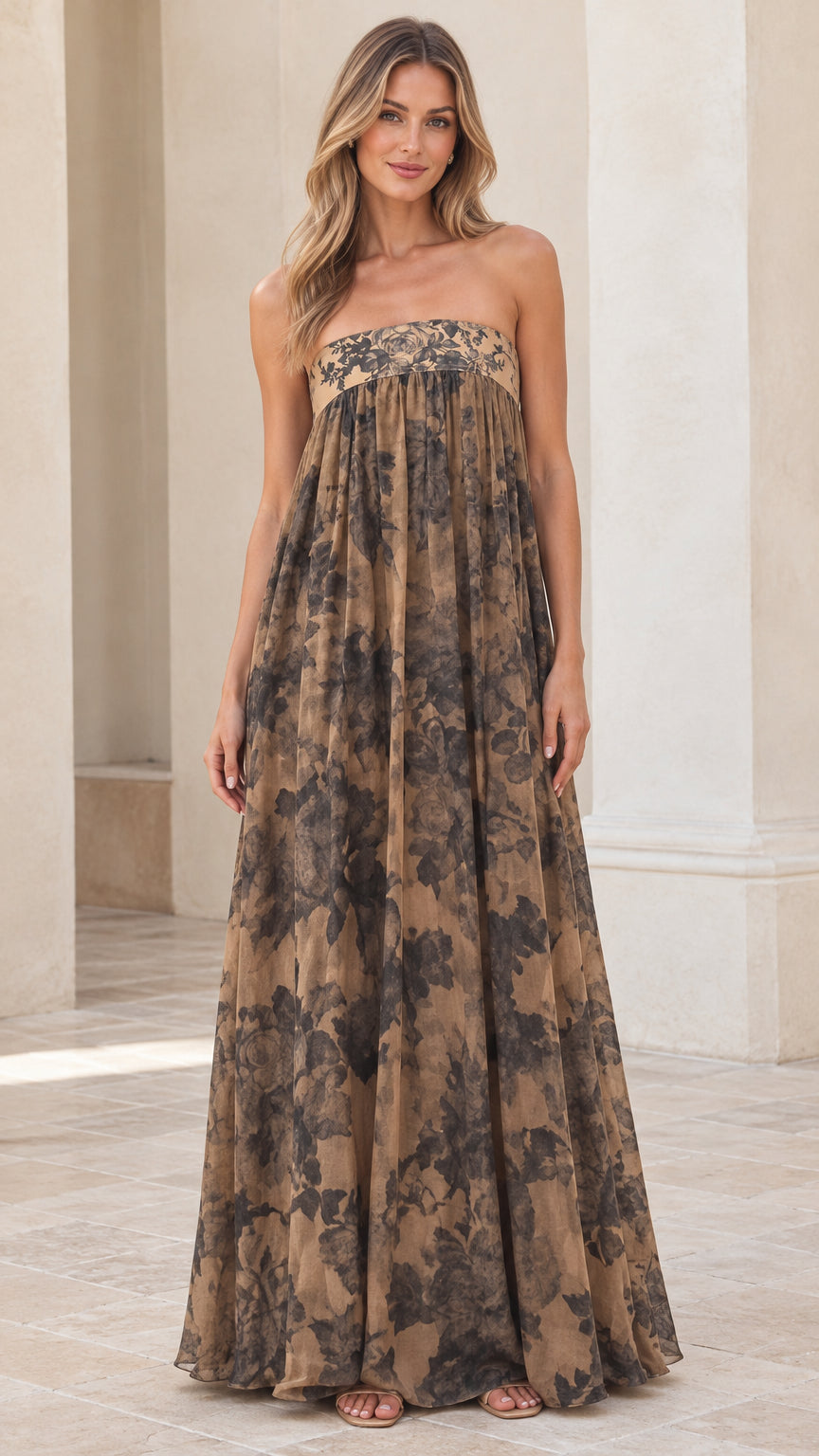 Front view of model wearing tan floral print strapless empire waist maxi dress