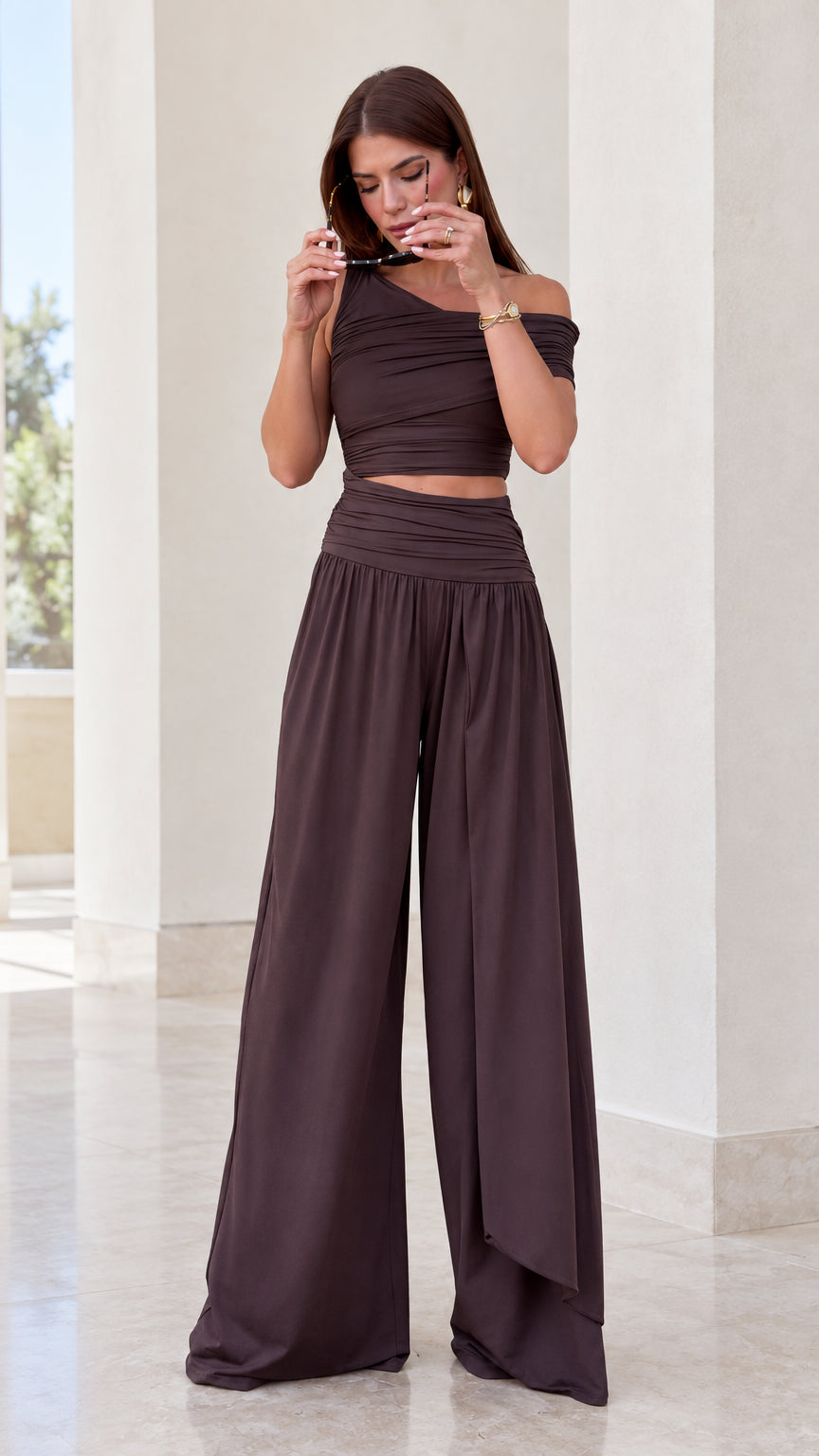 Front view of woman wearing chocolate brown asymmetrical ruched crop top and wide leg pants set