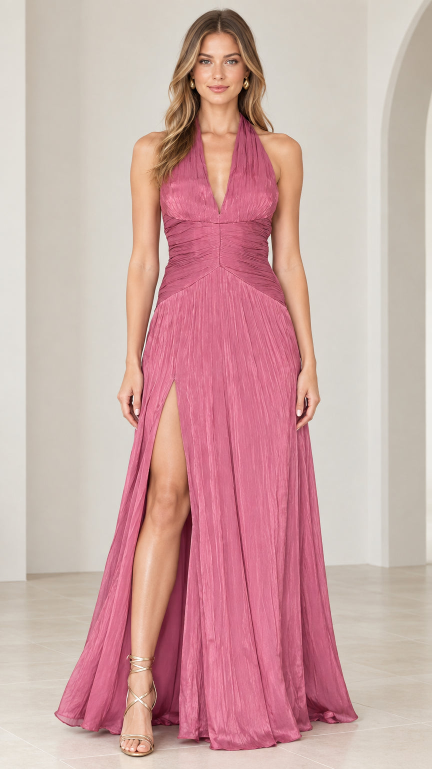 Full front view of a woman wearing a rose pink halter neck pleated maxi evening dress with a thigh-high slit