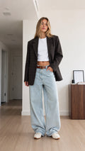 Full front view of model wearing charcoal plaid oversized blazer with wide-leg jeans