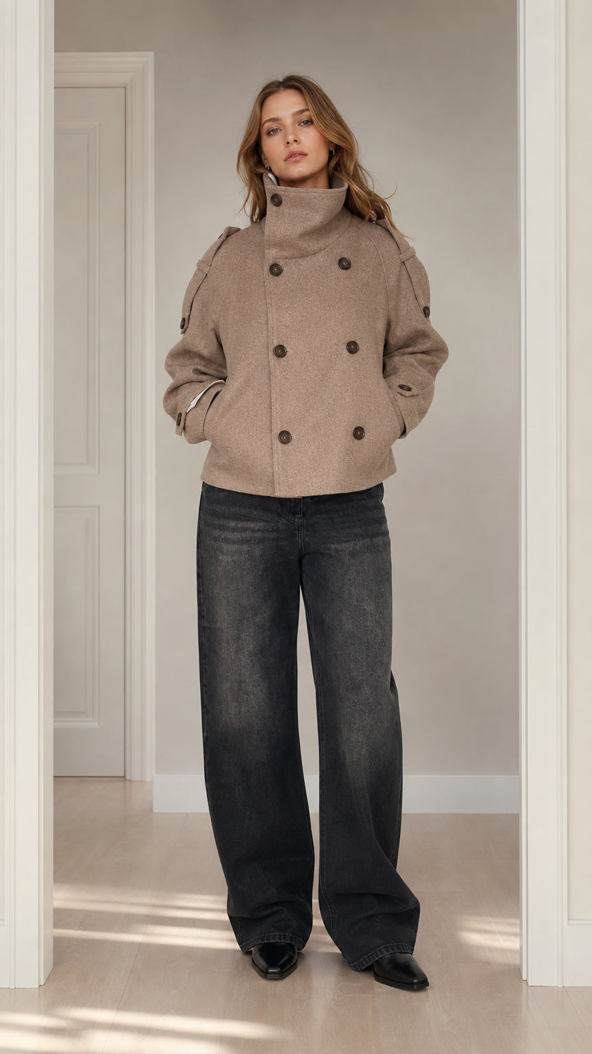 Front view of woman wearing taupe double-breasted short wool coat with stand collar and wide-leg dark denim jeans