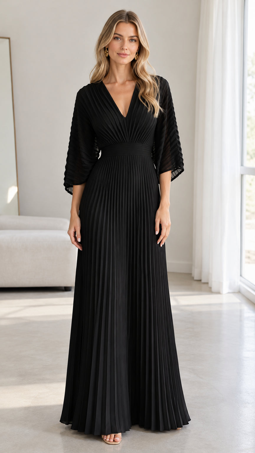 Front view of model wearing a black pleated V-neck maxi evening dress with flared sleeves