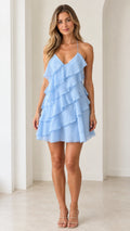 Front view of model wearing light blue tiered ruffle mini dress with spaghetti straps