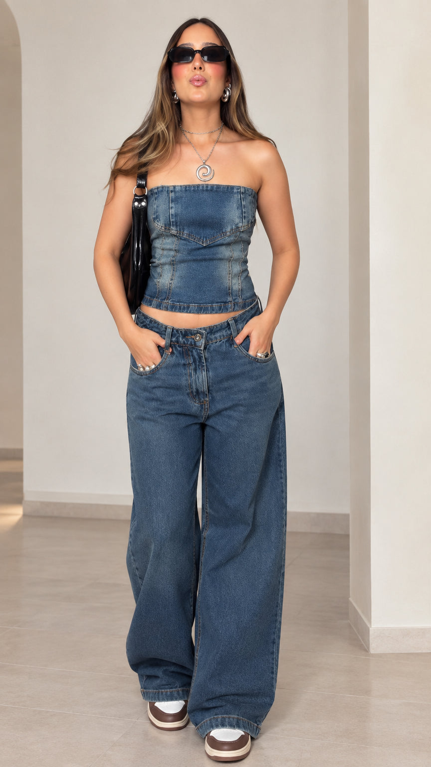 Full front view of model wearing blue strapless denim tube top and wide-leg jeans two-piece set