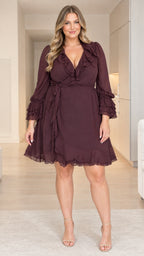Plus size woman wearing burgundy ruffle wrap mini dress with tiered sleeves - front view