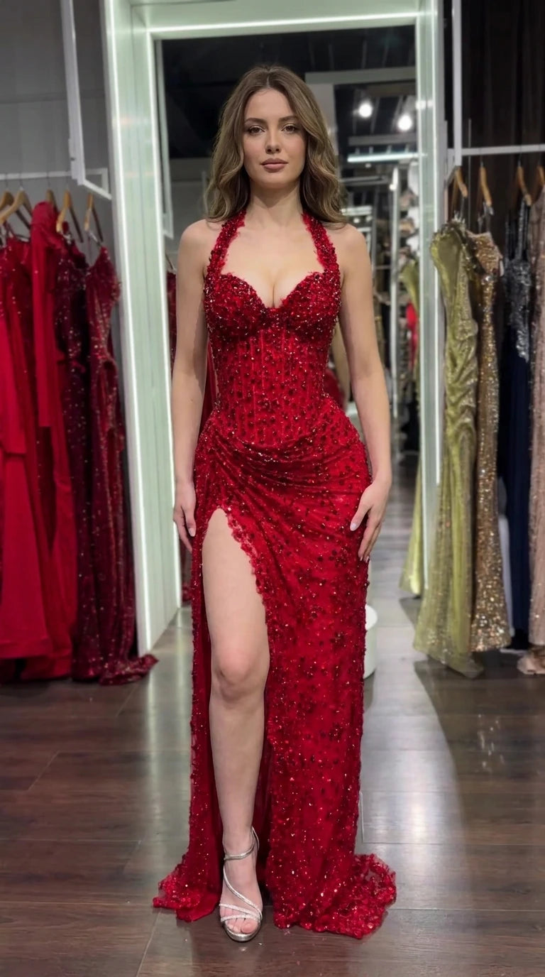 Front view of model wearing a red beaded corset halter evening gown with high leg slit
