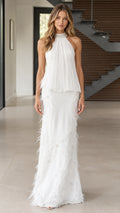 Front view of woman wearing white halter beaded neck pleated maxi dress